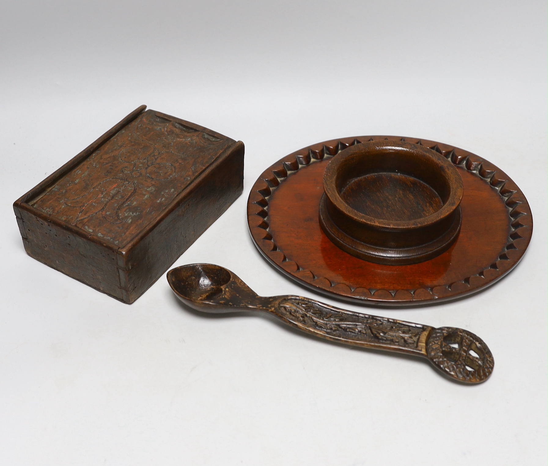 Treen including carved love spoon, four section box with incised decoration and a coaster, the largest 27cm wide